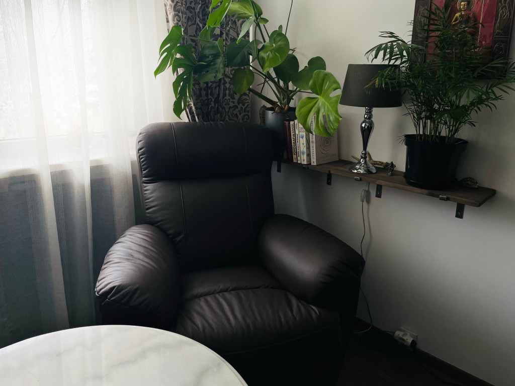 gabinet psychologiczny jelenia góra, wnętrze gabinetu psychologicznego, wygodne fotele dla klientów, biurko, grafiki na ścianie, zielone rośliny na półce, książki w gabinecie psychologa, prywatna praktyka psychologiczna Katarzyna karczmarz jelenia góra